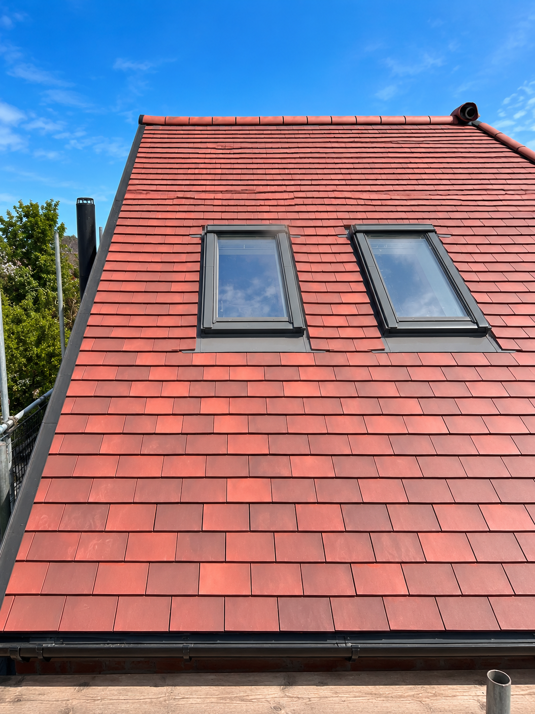 Completed red tiled roof with roof windows